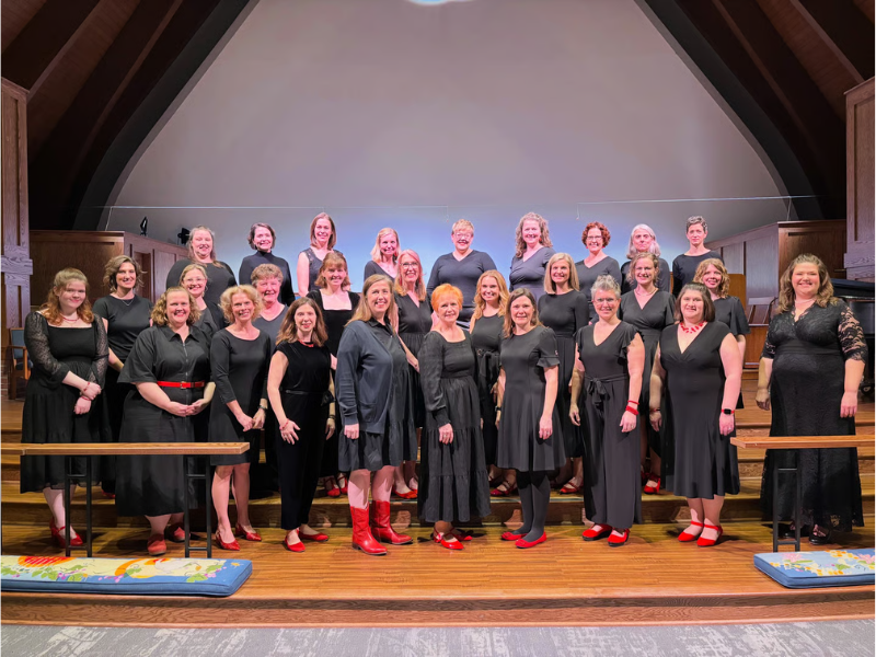 A women's choir dressed in black clothing with red shoes
